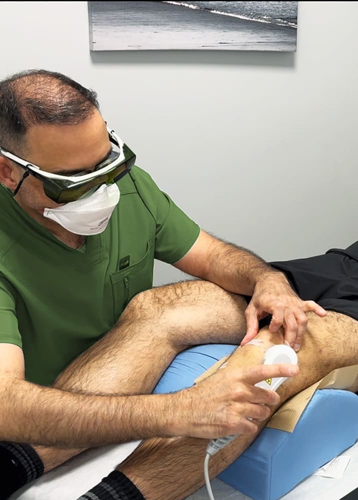 Ali Saadati gives laser thrapy treatment to patient