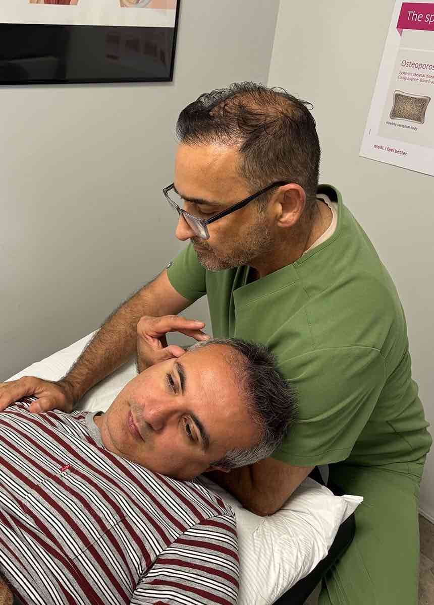 Ali Saadati gives osteopathy treatment on patient's neck